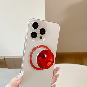 Macro detail of luxury red crystal faceted phone grip stand on white adhesive base