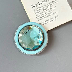 Macro detail of round light blue crystal phone grip with faceted gemstone surface