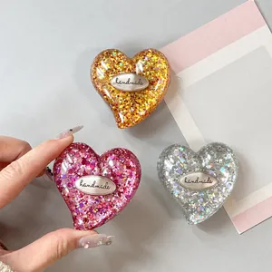 Dettagli di supporti per telefono glitterati a forma di cuore in rosa, oro e argento