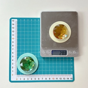 Macro view of crystal phone grip base with amber faceted gemstone and green gem detail