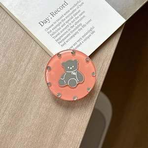 Detailed view of round pink bear phone grip with sparkling rhinestones and resin finish