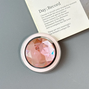 Detailed top view of pink crystal rhinestone phone socket on grey matte background