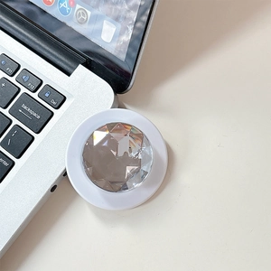 Macro detail of a white magnetic phone grip with a sparkling faceted diamond-cut crystal top