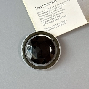 Detailed macro view of faceted black gemstone phone grip with transparent acrylic finish