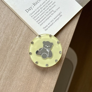 Detail shot of a round rhinestone bear phone socket on a soft aesthetic background