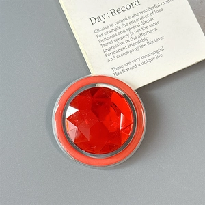 Detail of a luxury magnetic phone socket with faceted red gemstone and red circular rim