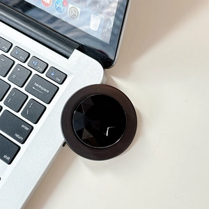 Close-up of black geometric diamond cut phone socket grip on a white office desk