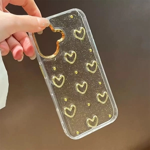 Clear iPhone case with glitter gold hearts and flower accents held against dark background