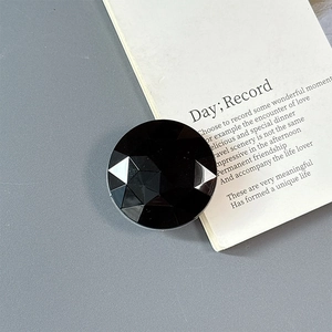 Close-up of black geometric faceted magnetic phone ring holder with mirror finish