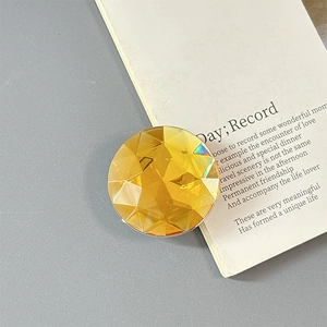 Macro shot of faceted amber crystal phone grip showing geometric cuts and shine