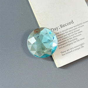 Close-up of a light blue multifaceted crystal magnetic phone grip with a glossy finish