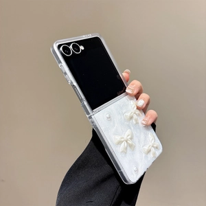 Close-up of a foldable phone case featuring 3D white bows and decorative pearls