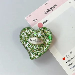 Macro di supporto per telefono a cuore con glitter e targhetta handmade su sfondo chiaro