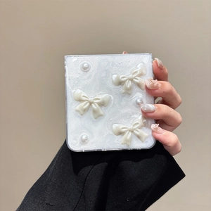 Sparkly white Samsung Z Flip fold phone case with 3D bows and pearls held in hand