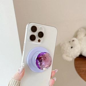 Purple diamond-cut crystal phone grip pop-out stand mounted on white mobile device