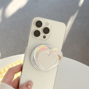 Close-up of holographic heart-shaped phone grip on white smartphone with a soft glow