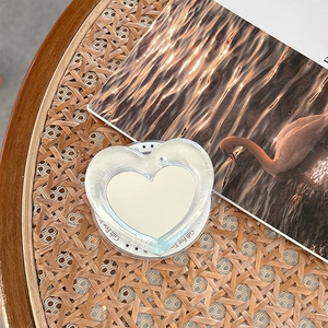 Detail shot of heart phone grip with Gift For You text on a textured wooden table