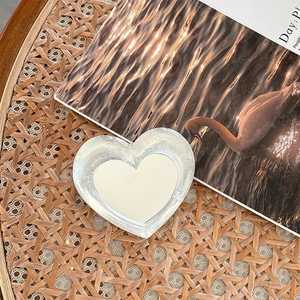 Detail shot of heart-shaped laser phone grip with mirror finish on a vintage book