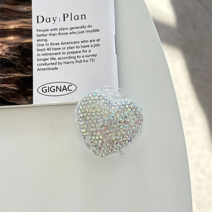 Macro detail of heart-shaped magnetic phone grip with iridescent rhinestone inlay