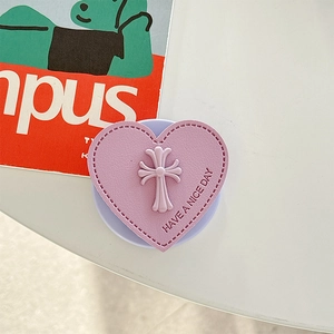 Makro-Detail der lila Herz-Handyhalterung aus Leder mit geprägtem Blumenkreuz-Emblem