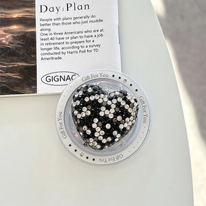Detailed macro view of heart-shaped magnetic phone grip with black and white rhinestones