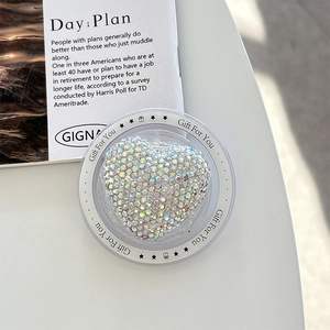 Close-up of heart-shaped phone grip with iridescent rhinestones and star gift motif