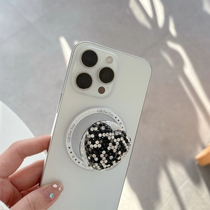Magnetic heart phone grip with black and white rhinestones on white smartphone