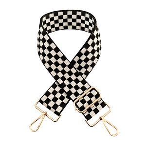 Detail of adjustable black and white checkered canvas strap with gold metal hardware