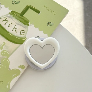 Close-up of a white heart-shaped vanity mirror phone socket on an aesthetic background