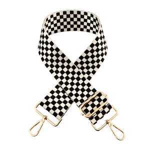 Close-up of black and white checkerboard 5cm wide bag strap with gold metal swivel hooks