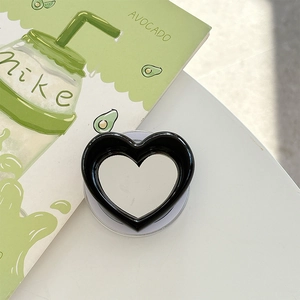 Detail of heart-shaped magnetic phone grip with integrated makeup mirror and black frame