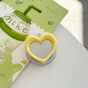Detail shot of heart-shaped magnetic phone grip with mirror in lemon yellow finish