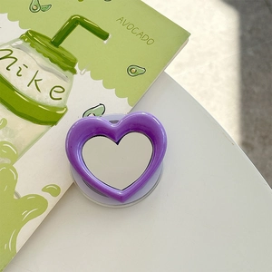 Macro view of purple heart-shaped magnetic phone grip with integrated makeup mirror