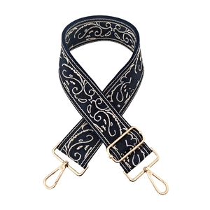 Detail of adjustable blue jacquard bag strap with vintage embroidery and gold hardware