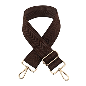 Detail of dark coffee brown 5cm wide woven bag strap with golden hardware and wave pattern
