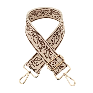 Close-up of paisley jacquard wide strap with golden metal swivel hooks and buckle