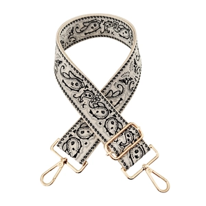 Detail of bohemian paisley embroidery on cream canvas wide adjustable bag strap with gold hooks