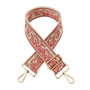 Close-up of ethnic paisley embroidered wide bag strap with gold metal lobster clasps