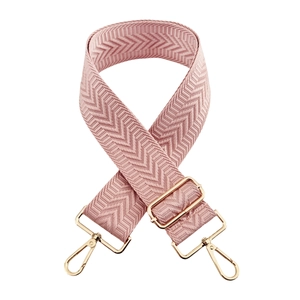 Close-up of pink chevron pattern bag strap with golden metal lobster clasps and buckles