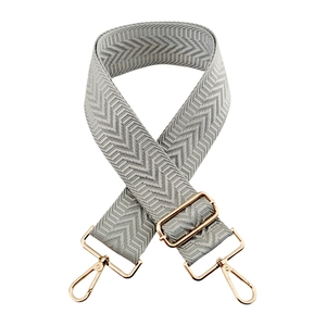 Macro detail of 5cm wide gray diamond pattern bag strap with gold metal buckle