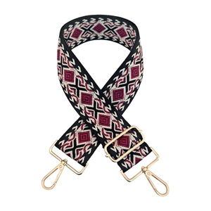 Close-up of geometric jacquard bag strap with gold metal hooks and ethnic pattern