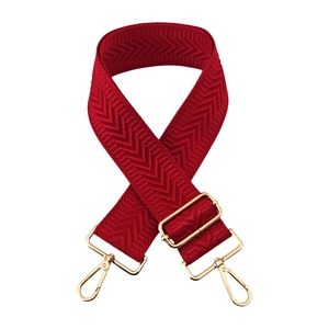 Close-up of a 5cm wide red woven bag strap with textured pattern and gold metal hardware