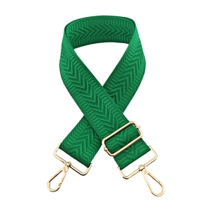 Close-up of green chevron pattern wide bag strap with polished gold hardware buckles