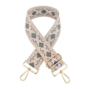 Detail of adjustable geometric diamond pattern wide strap with gold metal buckles
