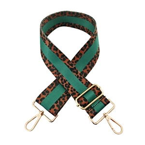 Detail of leopard print and green striped bag strap with gold metal hooks and buckle