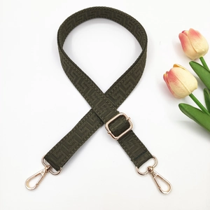 Detail of dark olive green woven bag strap with golden metal lobster clasps and texture