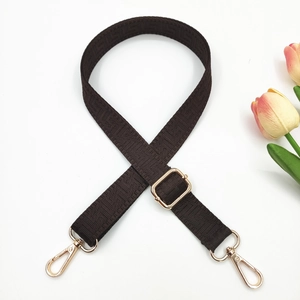 Detail of dark brown geometric woven strap with adjustable golden metal buckle and hooks