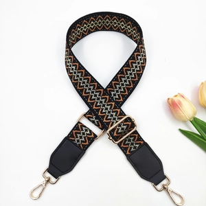 Detail of adjustable bohemian jacquard strap with geometric pattern and gold swivel hooks