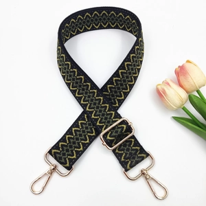 Close-up of adjustable woven bag strap featuring olive geometric waves and gold metal hooks