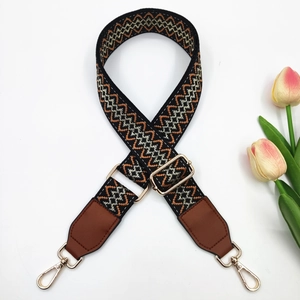 Detail of adjustable 3.8cm embroidered bag strap with golden buckles and leather ends
